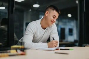 Estudiante de Grado Superior escribiendo y preparando oposiciones con Grado Superior